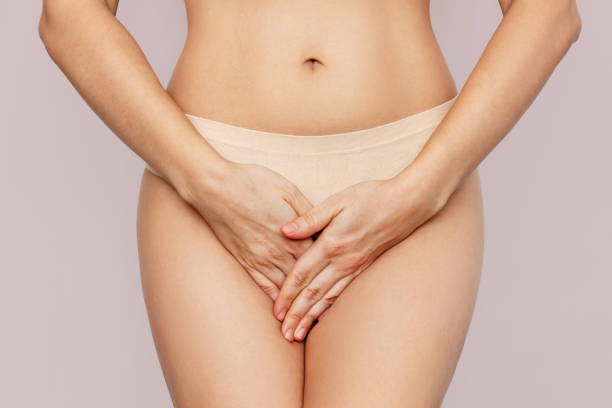Donna in biancheria intima che copre l'inguine con le mani